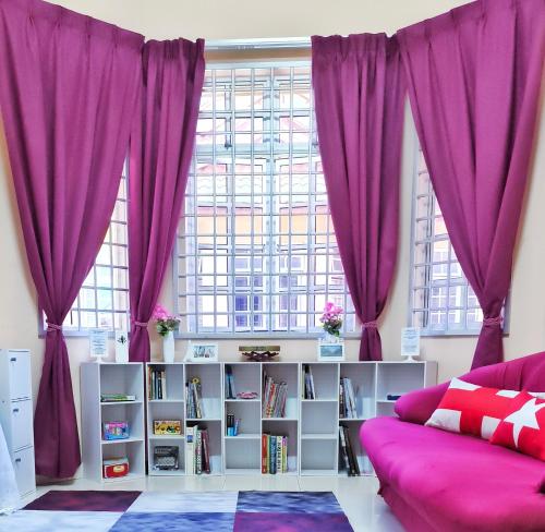 瓜拉丁加奴Ujana Damai - Cosy 5 bedrooms near UMT UNISZA的客厅配有紫色窗帘和沙发