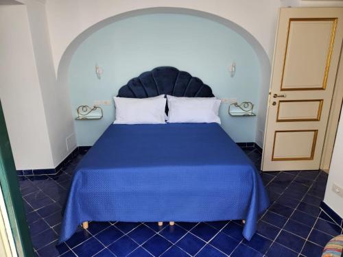 普莱伊亚诺Palazzo Rocco - Golden Suite - Praiano - Amalfi Coast的一间卧室配有蓝色床和蓝色棉被