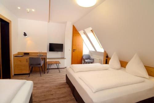 施帕尔特科朗酒店的一间卧室配有两张床、一张桌子和一台电视。