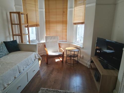 普里茅斯Ocean City Apartment-with parking的一间卧室配有一张床、一张桌子和一台电视。