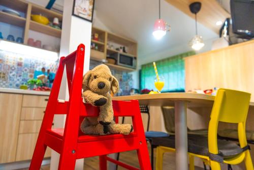 卡特兹奥布萨维Boho House 4 in camp Terme Catez的坐在桌子旁的红椅子上的泰迪熊