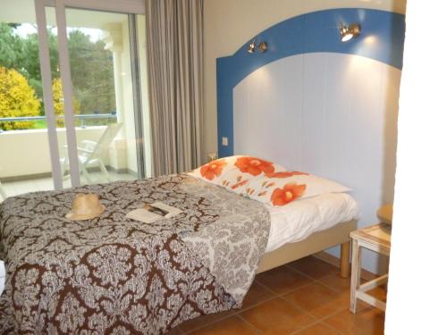 拉波勒Goélia - Résidence Royal Park的一间卧室配有一张蓝色床头板的床