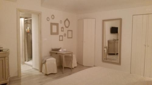 阿维利亚纳Novecento Charming Room的白色的客房配有桌子和镜子