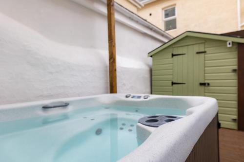 兰迪德诺The Cadnant Holiday House的带绿色棚的浴室内的热水浴池