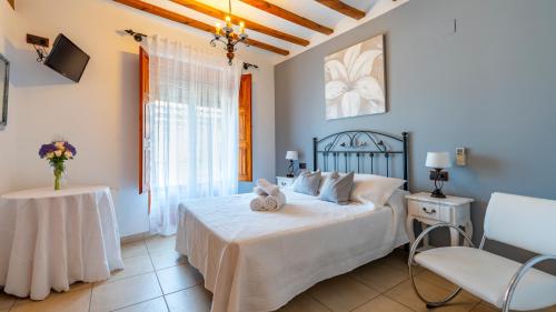 比拉法梅斯厄尔鲁洛酒店的卧室配有1张床、1张桌子和1把椅子