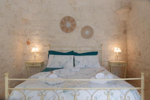 奥斯图尼Trulli Vulés的一间卧室配有白色床和2个床头柜