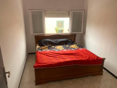 奥兰Akid的一张带红色毯子和窗户的床