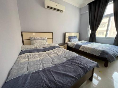 塞拉莱Fully Furnished 2bedroom apartment, Salalah, Oman的一间卧室设有两张床和窗户。