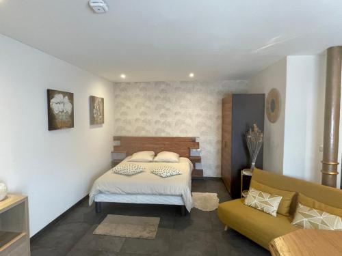 盖斯波尔塞姆Gîte de la bonne étoile的一间卧室配有一张床和一张沙发