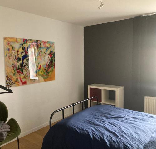 GesvesMaison Anthica的卧室配有一张床,墙上挂有绘画作品