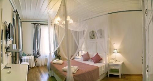 帕特雷帕特雷斯1821豪宅旅馆的卧室配有白色华盖床和粉红色床单