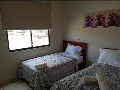 曼塔Hotel La Cultura的一间卧室设有两张床和两个窗户。