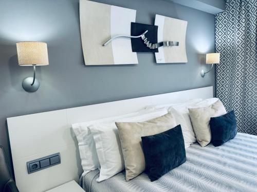 诺哈拉斯奥拉斯酒店的一间卧室配有带白色枕头的床