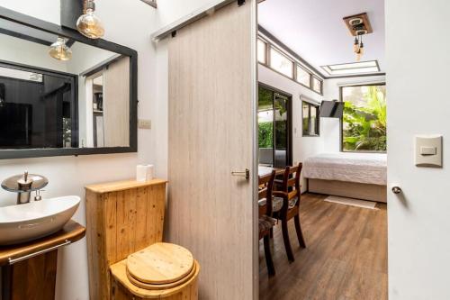 蒙泰韦尔德哥斯达黎加Tiny house Monteverde的一间带水槽的浴室和一张位于客房内的床
