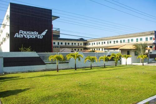 巴纳伊巴Pousada Aeroporto的一座棕榈树公园,位于一座建筑前