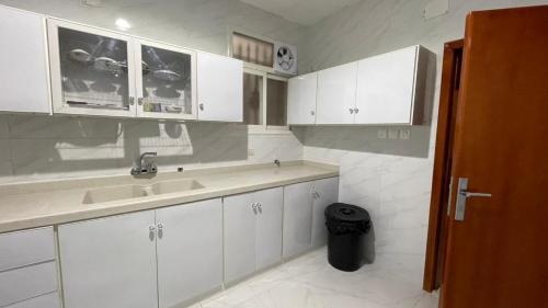 艾卜哈جنان المحاله的厨房配有白色橱柜和水槽