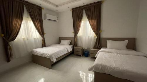 艾卜哈جنان المحاله的一间卧室设有两张床和两个窗户。