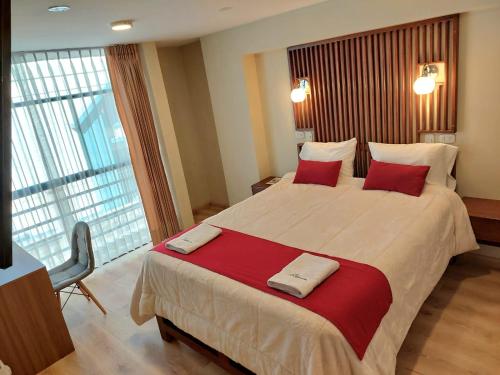 胡利亚卡Hotel California的酒店客房配有一张带红色枕头的大床