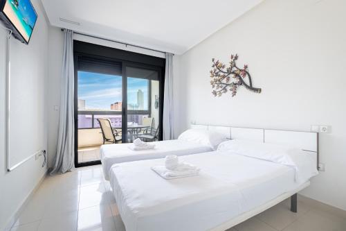 贝尼多姆Gemelos 26 Resort Apartment 9-C Levante Beach的白色卧室设有两张床和大窗户