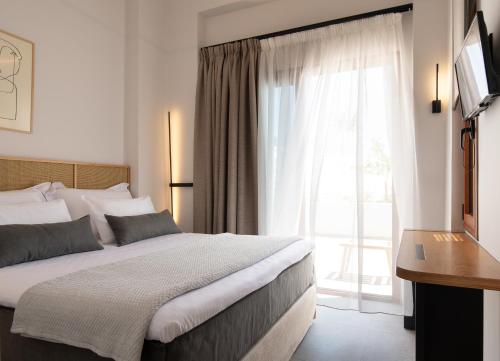 阿莫利亚尼岛Sun rise Villas ammouliani的一间卧室设有一张床和一个大窗户