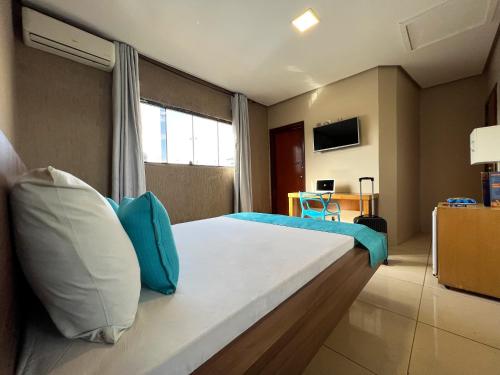 塔瓜汀加Dok Brasília Hotel Unidade Águas Claras的一间卧室配有一张带蓝色和白色枕头的床