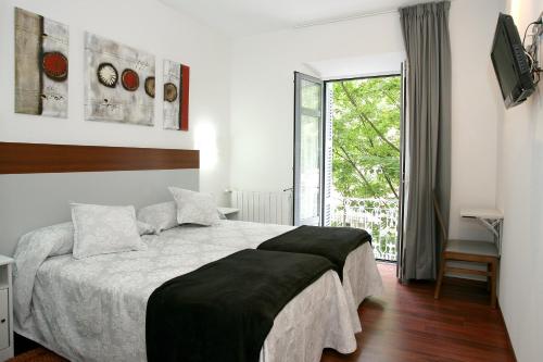 圣塞瓦斯蒂安Hostal San Ignacio Centro的一间卧室设有一张大床和一个窗户。