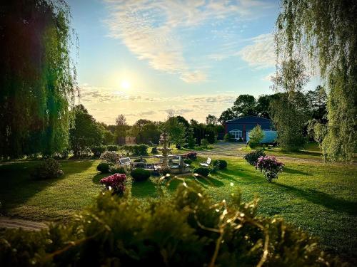 瓦乌奇Agroturystyka Hotel Noclegi Pałac Camping的鲜花盛开的花园,蓝色的建筑背景