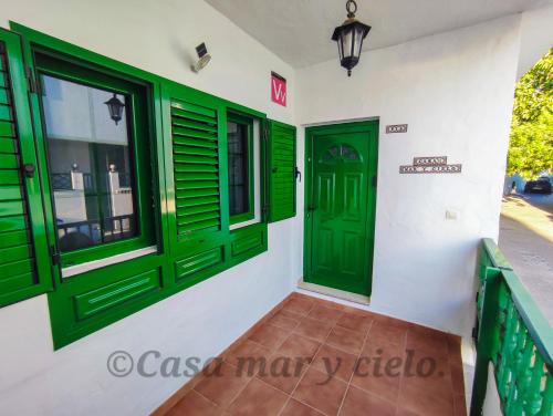 普拉亚布兰卡Casa mar y cielo的建筑中设有绿门和窗户的房间
