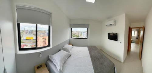 马塞约Apto Corais do Mar 290m Praia Jatiuca的一间卧室设有一张床和两个窗户。