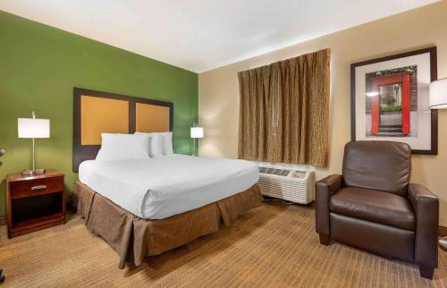 印第安纳波利斯印第安纳波利斯西北大学城长住美国酒店的配有一张床和一把椅子的酒店客房