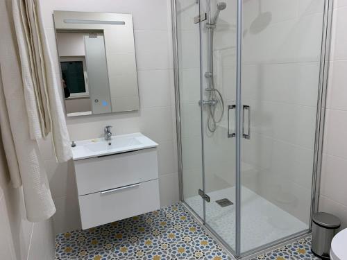 塞亚Casa do Bairro的一间带玻璃淋浴和水槽的浴室