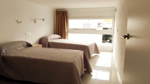 科尼尔-德拉弗龙特拉El Rincón de Madera - Apartamento céntrico en Conil的一间医院间,设有两张床和窗户