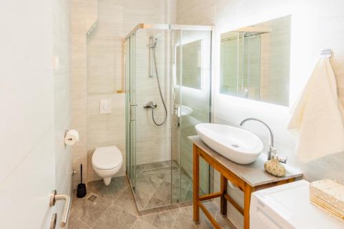 昆博White Apartment的带淋浴、盥洗盆和卫生间的浴室