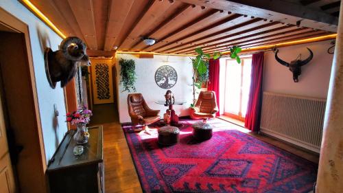 洛弗附近魏斯巴赫Gasthof Geronimo的一间铺有红色地毯的客厅