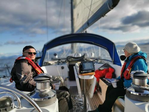 哈尔斯塔Liveaboard sailing tour in Harstad islands的坐在船头上的两个人