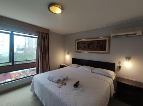 利马Inti Llaqta Hotel & Suites的卧室设有一张白色大床和一扇窗户。