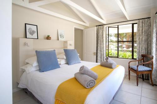 赫曼努斯High Season Farm Luxury Cottages的卧室配有带蓝色枕头的大型白色床