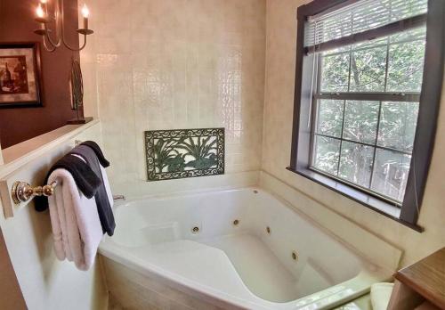 尤里卡斯普林斯D'vinery Rock Cottage/ #6的带窗户的浴室内的白色浴缸