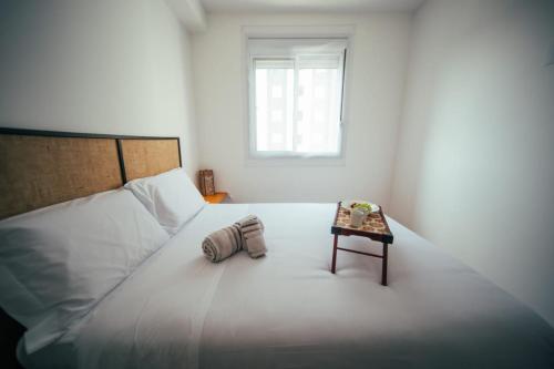 圣保罗Apartamento confortável próximo ao Transamérica Expo的白色卧室配有床和桌子