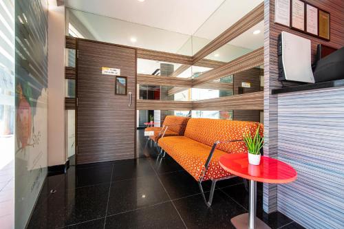 新加坡Fragrance Hotel - Oasis的一个带橙色沙发和桌子的办公室