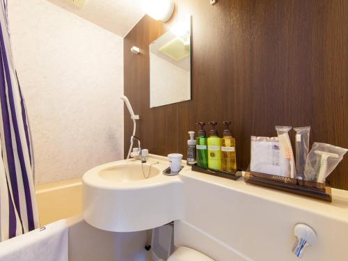 相模原市HOTEL LiVEMAX BUDGET Sagamihara的一间带水槽、卫生间和镜子的浴室
