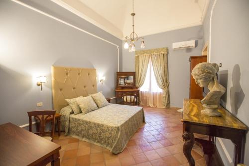 切法卢拉霍宫旅馆的一间卧室配有一张床和一张桌子及雕像
