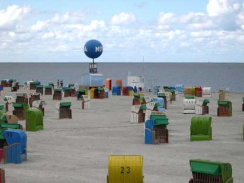 多纳莫塞尔Ferienhaus in Dornumersiel 20-069的沙滩上有许多五彩缤纷的椅子和蓝色的球