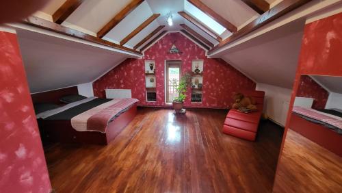 奥拉迪亚Casa in Oradea !的一间卧室设有红色的墙壁和一张床,铺有木地板