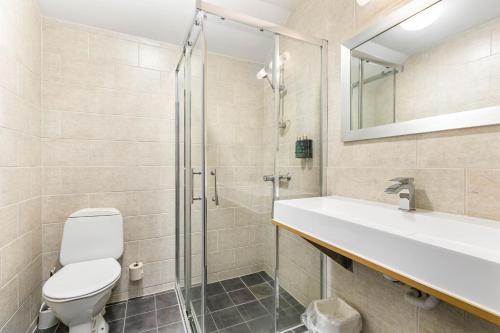 莫斯Storebaug Hotell & Kro的浴室配有卫生间、盥洗盆和淋浴。