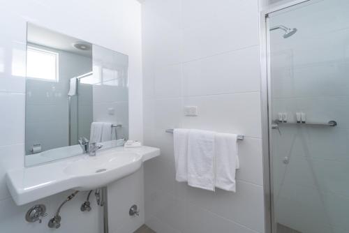 蚬壳港湖景汽车旅馆的白色的浴室设有水槽和淋浴。