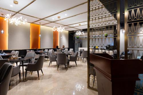 上海上海帝璟雅致酒店(上海韩国街万象城店)的一间带桌椅的餐厅和一间酒吧