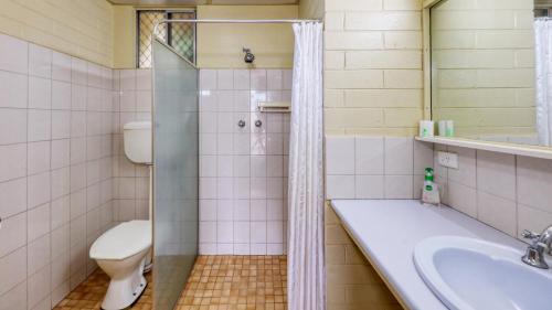 布罗肯希尔绿洲汽车旅馆的带淋浴、卫生间和盥洗盆的浴室