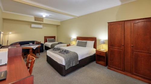 布罗肯希尔绿洲汽车旅馆的小酒店客房配有两张床和书桌