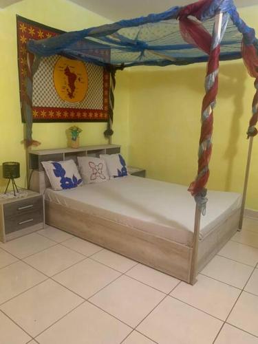 OuanganiMaison T3 75m2的一间卧室配有一张带天蓬的床